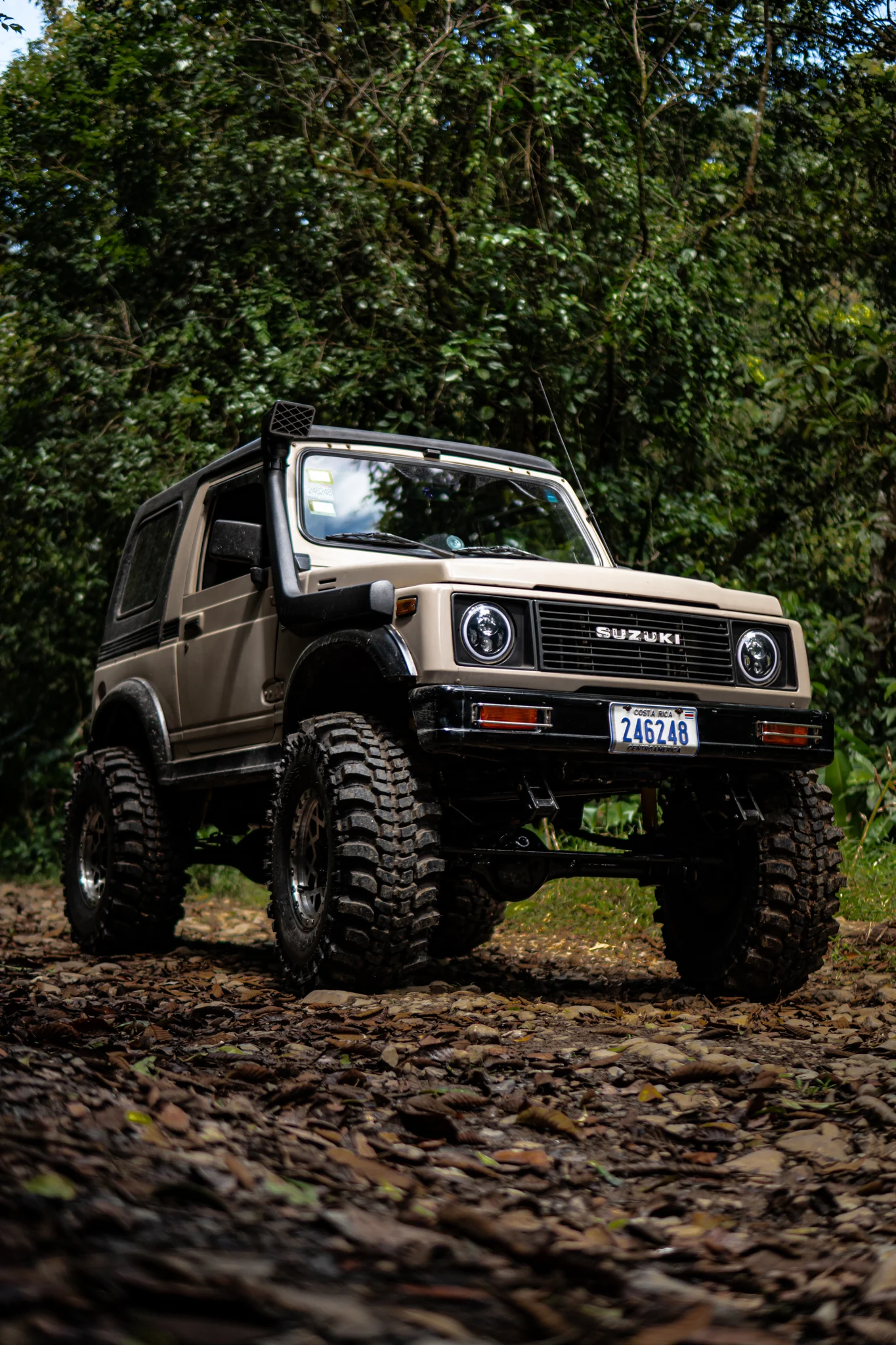 Beige Suzuki Samurai photographed from a low angle on an off-road trail