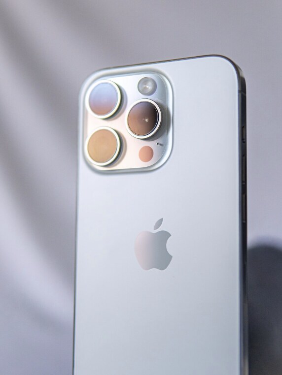 Close-up of a white iPhone camera module on a soft white background