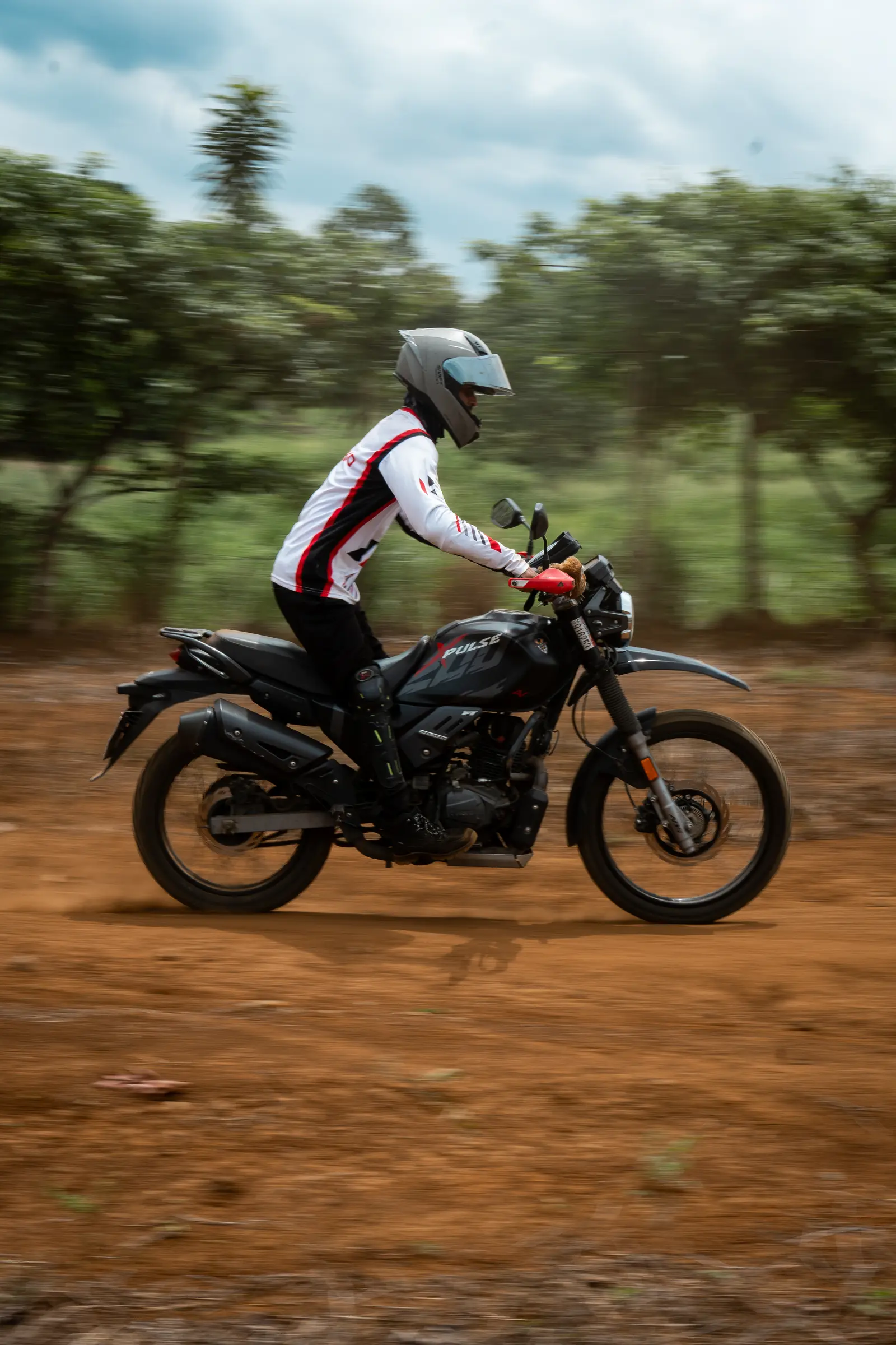 Motorcyclist in a white helmet riding through a dirt course