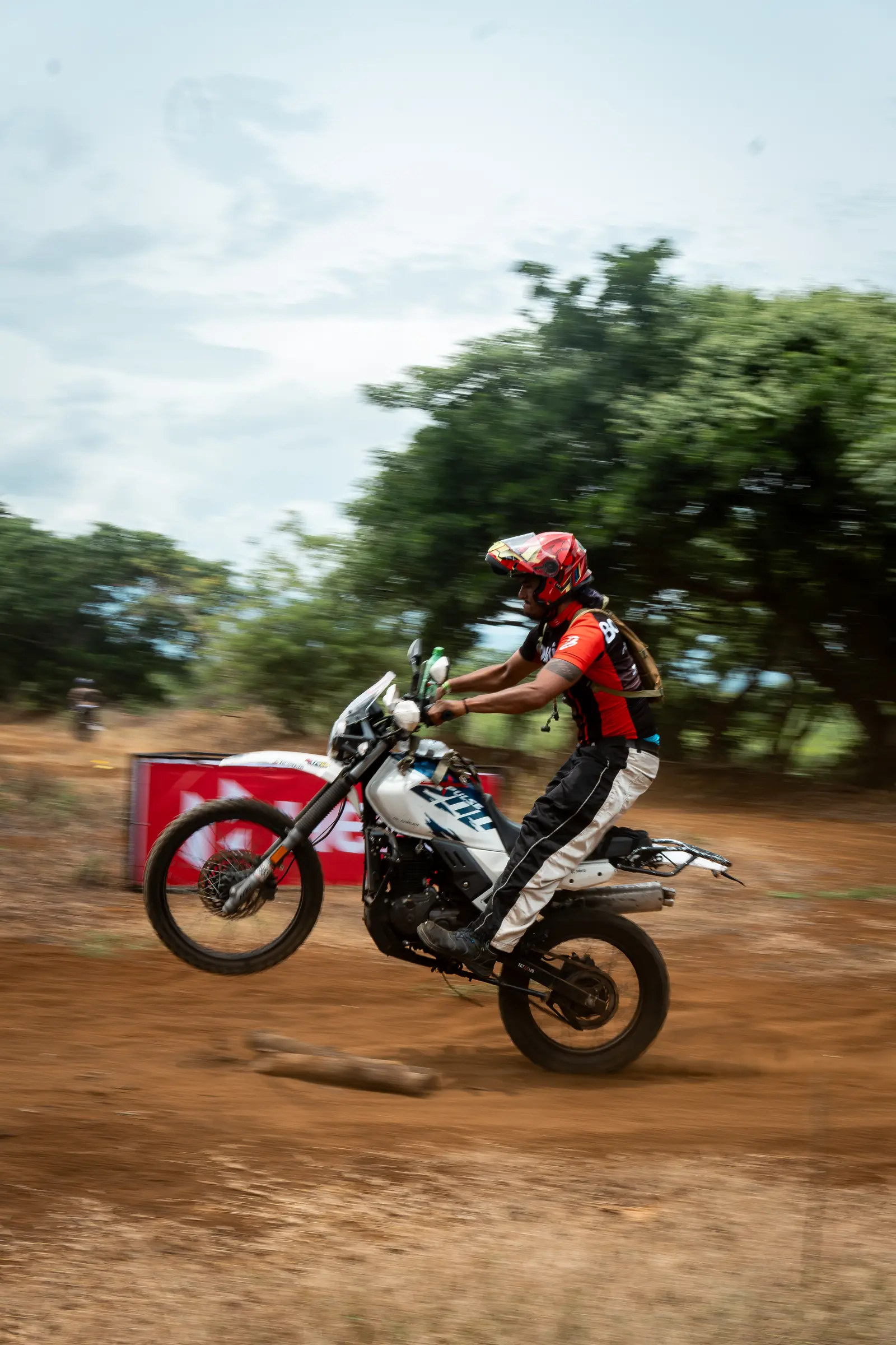 Motorcyclist lifting the front wheel on a dirt track